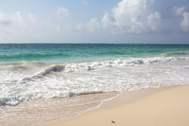 足跡と波が交差する砂浜の記憶