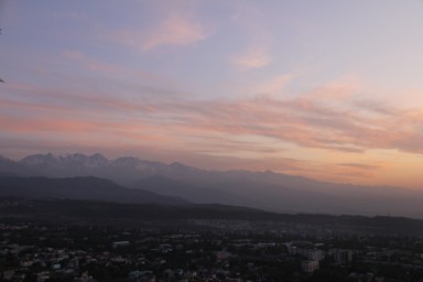 アルマトイのコク・トベの丘から見上げる雪をかぶった山脈の夕暮れの光景