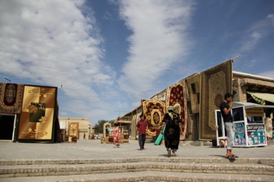 ブハラの大きな絨毯をいくつもたらして販売する市場の光景