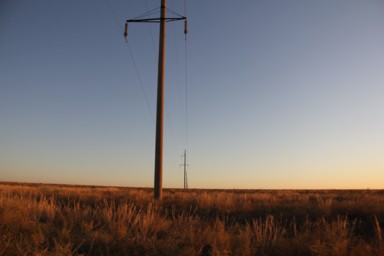 カザフスタンの何もない大地を電柱の列が直線に並ぶ