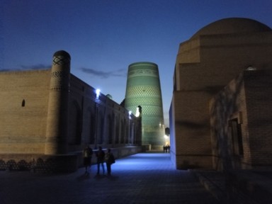 ヒヴァの夜のブルーにライトアップされた通りとカルタミナール