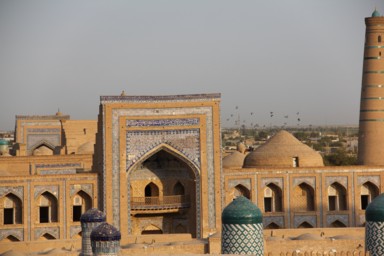 ヒヴァのアラクリ・ハーン・マドラサと鳥が集まって飛ぶ光景