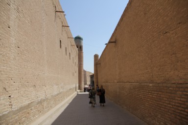 ヒヴァのレンガ造りの高い塀の真ん中を通る路地の景色