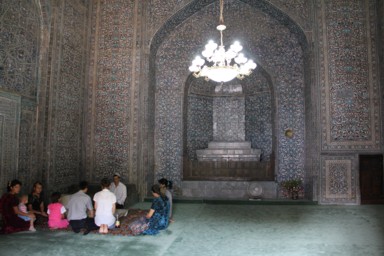 ヒヴァの廟の中でお祈りをする家族