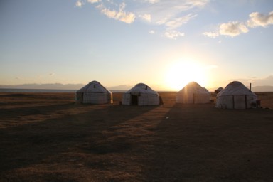 ソンクル湖で大地に近づいた夕日がユルタをテラス光景