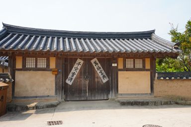 河回村の広い門に文字の紙を貼る