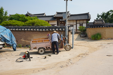 河回村の村人が三輪バイクを修理している風景