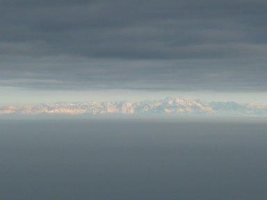 空と大地の裂け目から見える雪をかぶった山々