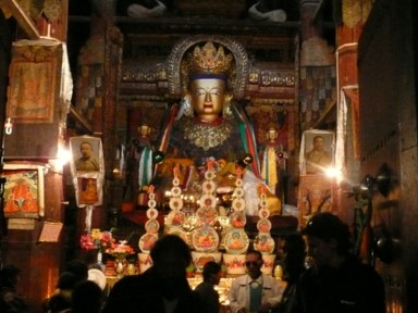 パンコルチョンデの寺院内部の金色の仏像とパンチェンラマ10世の写真