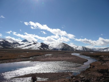 低い雪山とぬかるんだ道