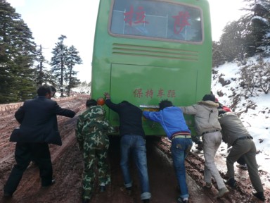 泥にはまり乗客が大型バスを押して脱出