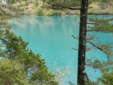 九寨溝の透き通る青い水と空が混ざる池