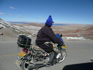 極寒の中を毛布にくるまりバイクに乗る地元民
