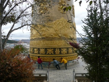 シャングリラの独克宗古城の巨大マニ車を回す人々