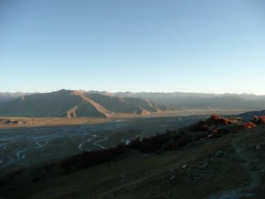 タクツェで山のすき間から伸びる日の出の光