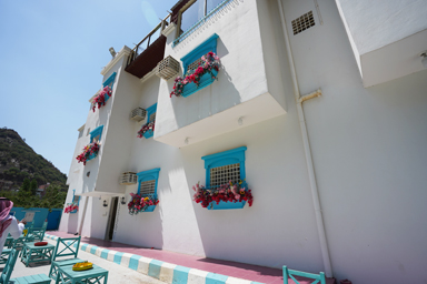 地元の人おすすめの白い建物に水色の窓飾りの養蜂場ハニーハウス