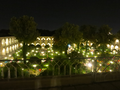 アバシ・ホテルのライトアップされた中庭のチャイを飲みながら交流する人々