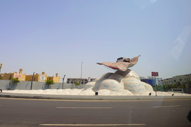 ラウンドアバウトの道路の真ん中に置かれているのは魔法のじゅうたんに乗った車のマジックカーペットのオブジェクト