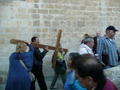エルサレムの旧市街を巨大な十字架を持って涙しながら歩く人々