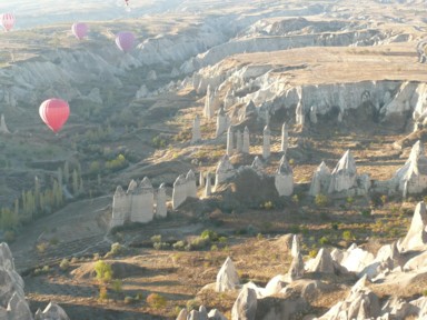 朝日が奇岩と気球を照らす風景