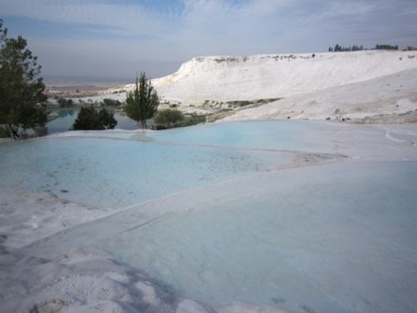 裸足で歩くパムッカレの白い石灰棚の青い水の中