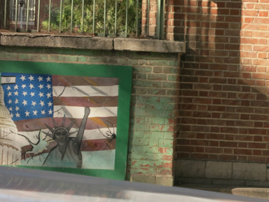 旧米国大使館の外壁にある銃弾を受けたアメリカ国旗と骸骨の自由の女神のペイント