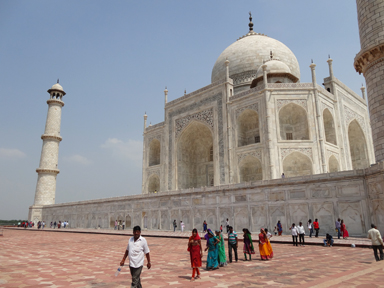 タージ・マハールの白い姿と鮮やかなサリーを着たインド人の光景
