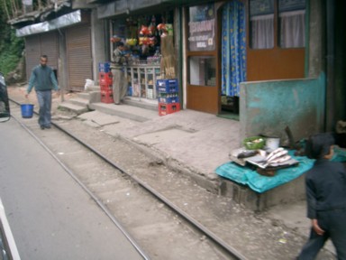 ダージリンのミニトレインの線路が山道の家の前を通る風景