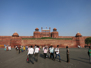赤い城の重厚な城壁と門がそびえる歴史的建造物。