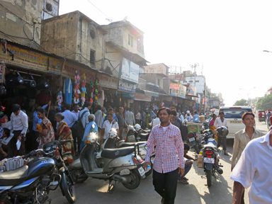 浅草のような下町の市場に人があふれ混沌とする様子。