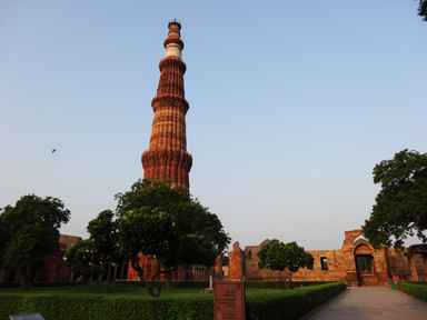 クトゥブ・ミナールの高くそびえる塔を見上げる構図。