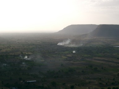 ダウラターバードから見下ろした地平線まで続く大地とダイナミックな山と家から煙が上がる様子