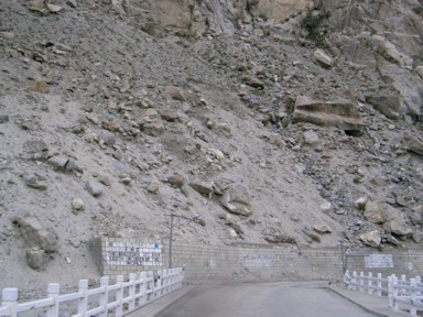 カラコルムハイウェイの道路に落ちる落石と山からも落ちてきそうな岩が転がる光景