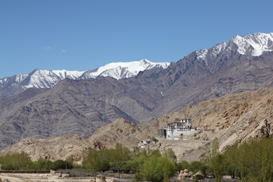 遠くでも目立つ丘に建つチェムレ寺とその後ろにそびえる雪山
