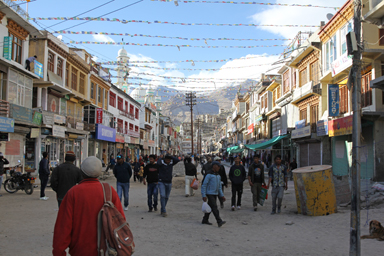 レーのメインバザールの商店が並び旗がたくさんかかったにぎやかな様子