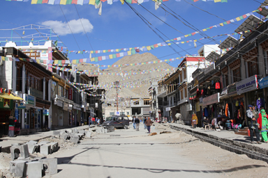 レーのお土産屋が並び旗が幾重にも旗めくメインバザールの横道の景色