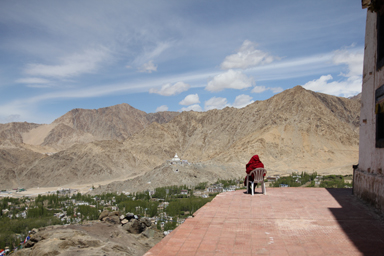 レーの絶景の中で日光浴をする僧