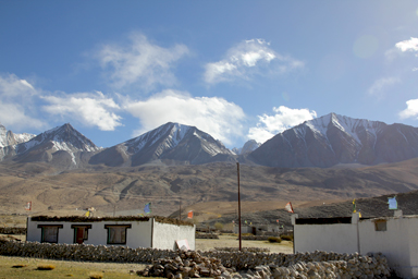 メラクのチベット様式の村と真後ろにそびえる高い山