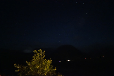 早朝の朝日を見るツアーの車のライトが列になる