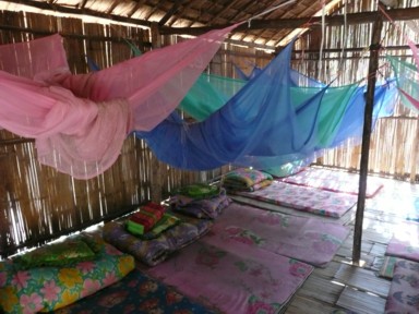 チェンマイ郊外の首長族の集落で藁引きの高床式の部屋に蚊帳がある風景
