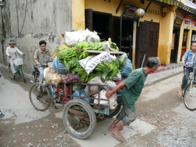 三輪の荷台に大量の荷物を載せて人力で動かす物売り