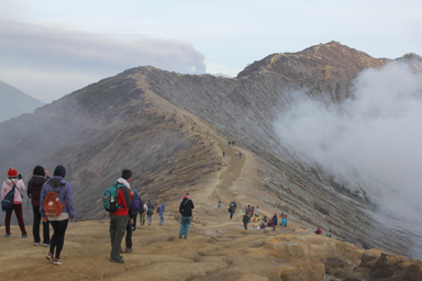尾根沿いの荒れた波打つ大地と遠くの火山ガスは観光客を圧倒