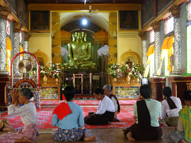 インレー湖の湖畔にあるインデインの寺院の中でただ座るだけの祈る人々