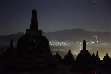 夜明け前に街の灯りとシルエットのボロブドゥール