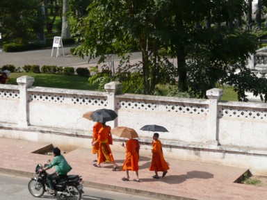 日傘を差した僧が歩くラオスらしい風景