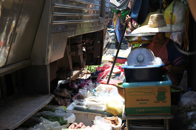 メークロン市場の列車と商品の食料品がギリギリ数センチのすれ違いをしている光景