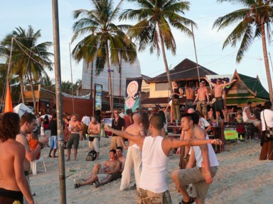 パンガン島のフルムーンパーティーで朝日を浴びながら踊る人々