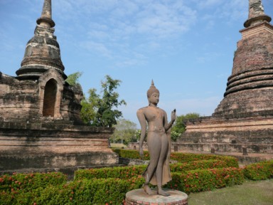 上品に歩く仏さまの像が立つスコータイの遺跡