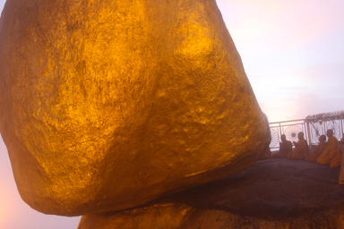 ゴールデンロックの前で僧たちが祈りを上げると雲が覆い夕日でオレンジ色に染まりだす