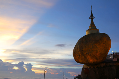 夕日が沈み空に影が伸びるその先には金の岩